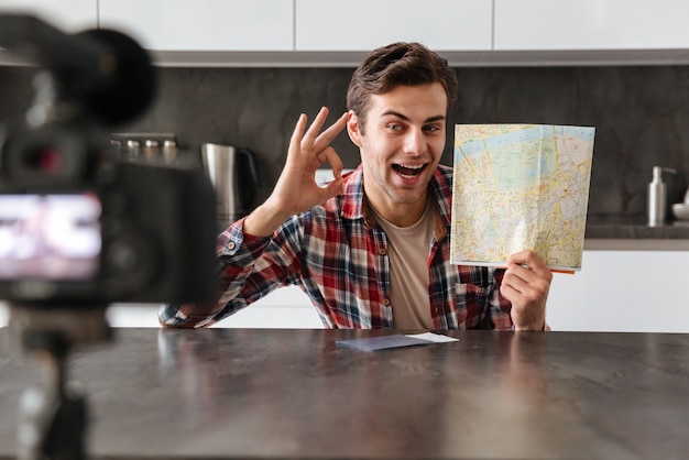 Joyful young man filming his video blog episode