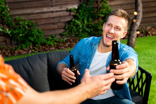 Joyful young man passing out a beer