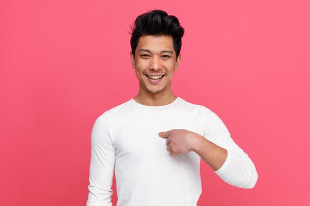 Joyful young man pointing at himself 