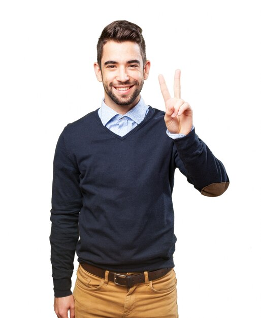 Joyful young man showing the victory gesture