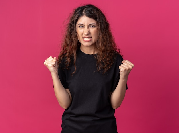 Free photo joyful young pretty girl  doing yes gesture isolated on crimson wall with copy space