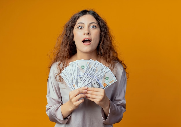 Joyful young pretty girl holding money