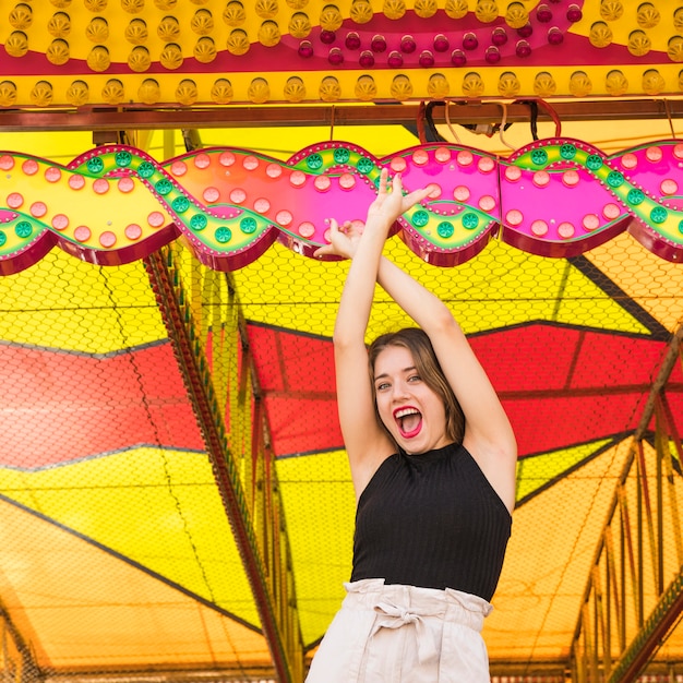 Foto gratuita giovane donna allegra che fa divertimento al parco di divertimenti