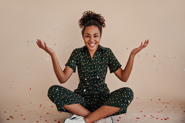 Joyful young woman posing with hands up