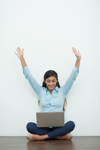 Joyful Young Woman Working on Laptop on Floor