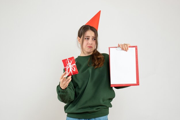 joyless girl with party cap looking at her document on white