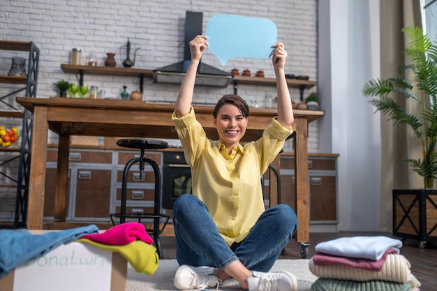 Joyous Caucasian female volunteer calling for clothing donation