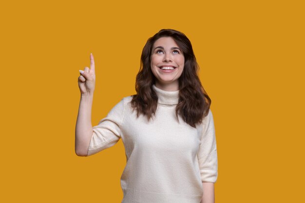 Joyous lady with the lifted forefinger looking upwards