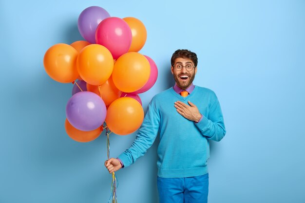 Joyous surprised man being impressed by something positive, being on party in club