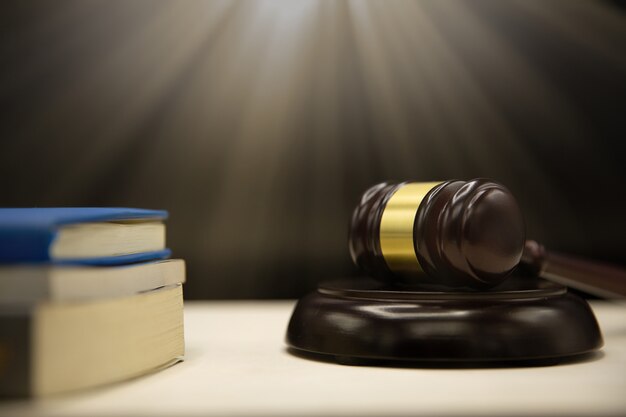 책과 나무 테이블에 판사 망치입니다. 법과 정의 개념 배경입니다.