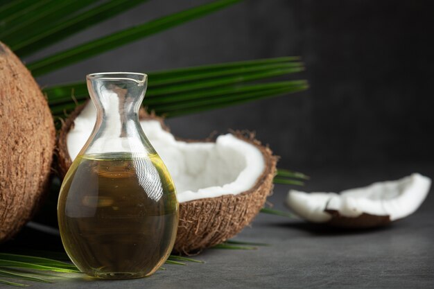 jug of coconut oil whit coconut put on dark background