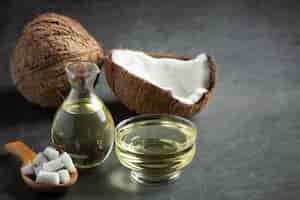 Free photo jug of coconut oil whit coconut put on dark background