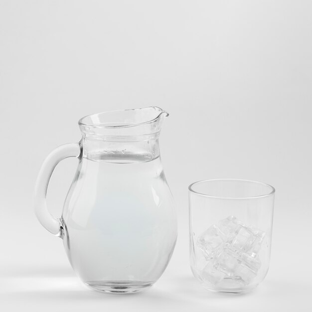 Кувшин с водой и стакан, наполненный льдом