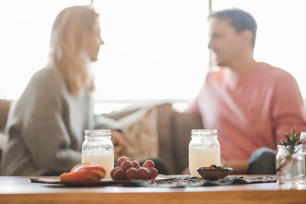 Juice and fruit on table in front of couple at restaurant