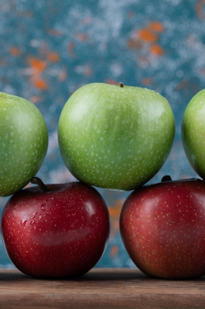 Free photo juicy apples on row on wooden board.