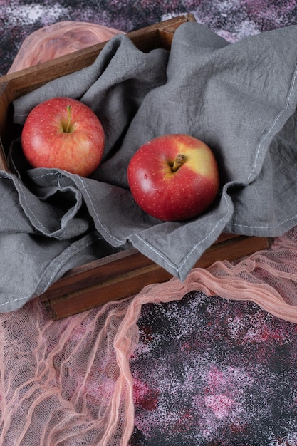 Juicy apples on rustic wooden box.