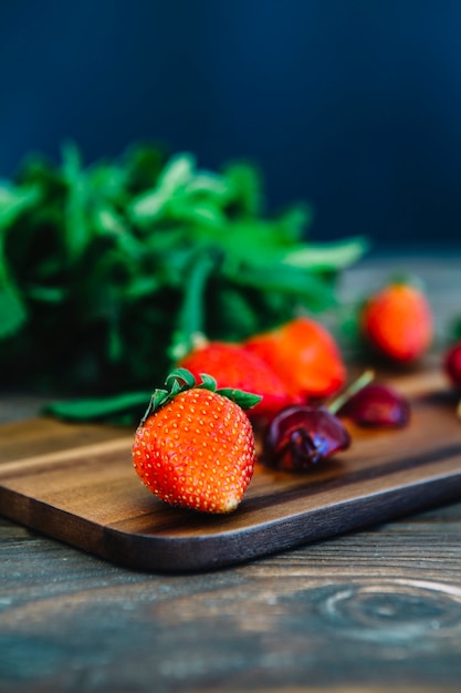 Juicy cherries and strawberries on chopping board