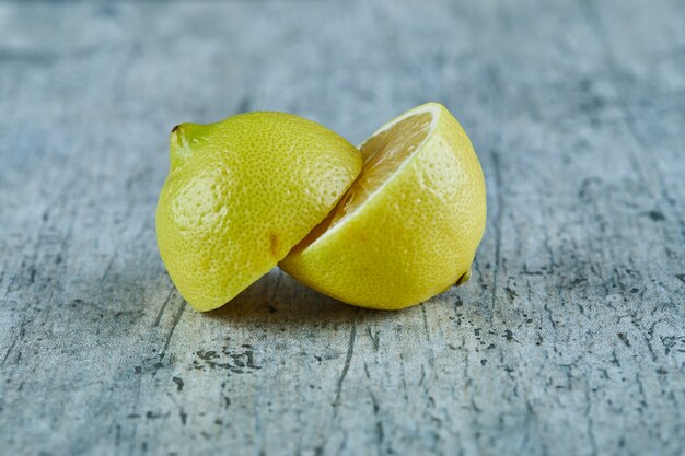 Juicy half cut yellow lemon on marble surface