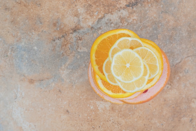 Бесплатное фото Сочные дольки лимона, апельсина и грейпфрута на мраморном фоне.