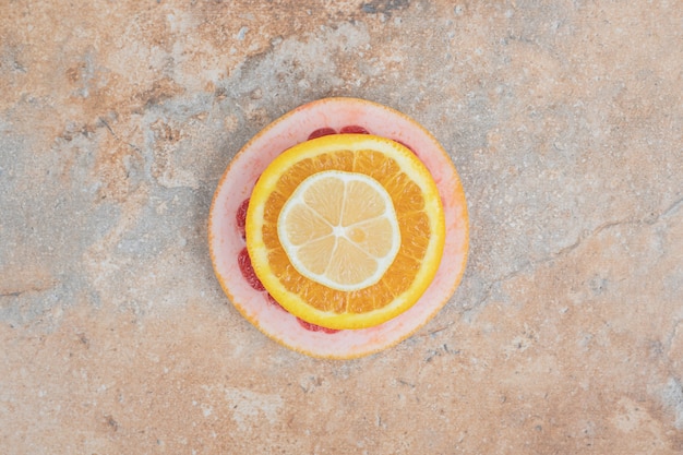 Сочные дольки лимона, апельсина и грейпфрута на мраморном фоне.