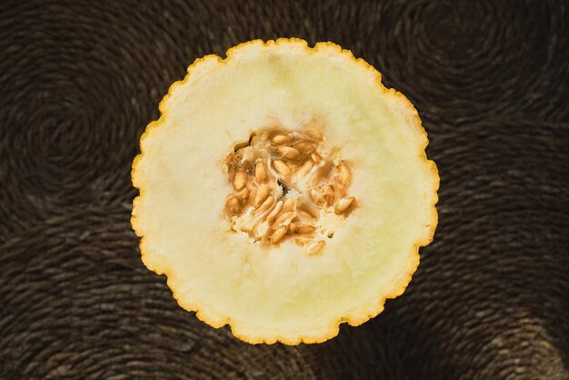 Juicy melon cut in half on a straw deck top view organic fruit advertising idea from a local farmer's market Healthy seasonal food article background or concept