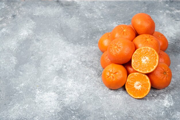 Juicy orange fruits with slices on stone table .