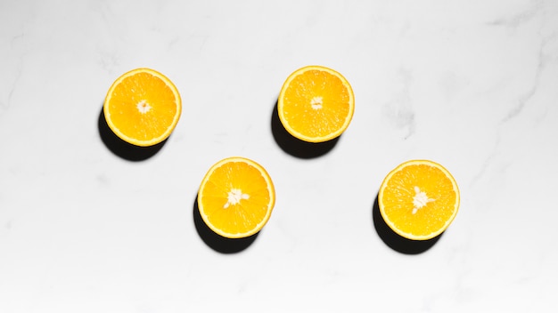 Free photo juicy oranges halves on light surface