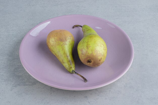 Juicy pears on a platter on marble 