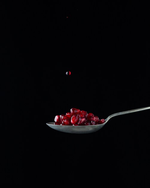 Juicy pomegranates on spoon
