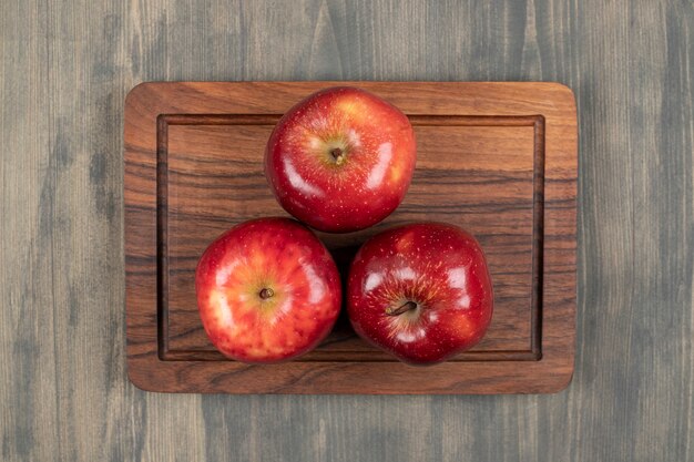 Juicy red apples on a wooden cutting board. High quality photo