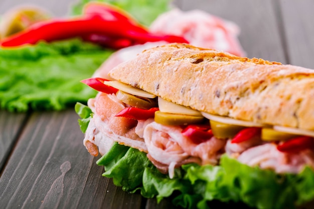 無料写真 ジューシーな赤い唐辛子は、サンドイッチの全粒粉のパンの下から見える