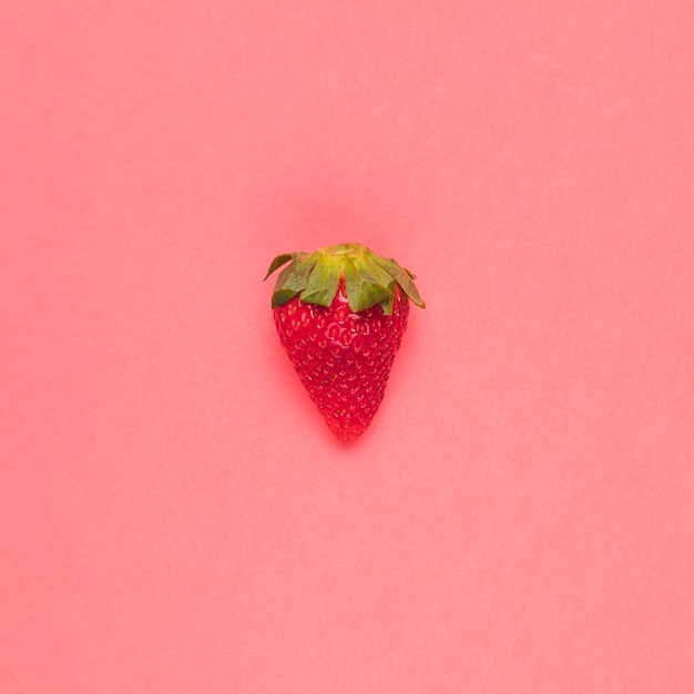 Juicy red strawberry on pink background