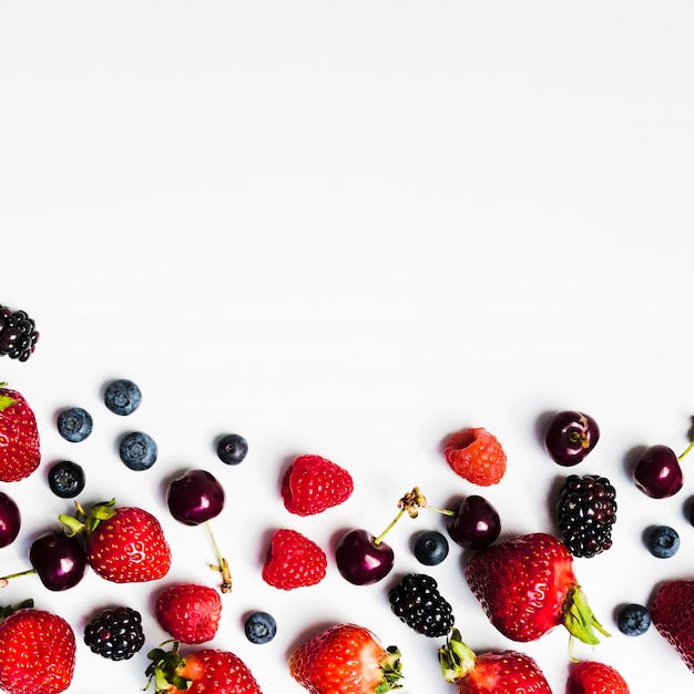 Juicy seasonal berries on light surface