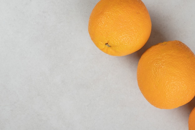 Juicy whole oranges on gray surface