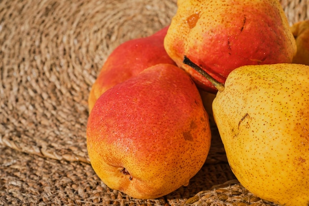 Free photo juicy yellow pears on a straw lining close up selective focus healthy eating concept organic fruits from a farmers market idea for background or wallpaper