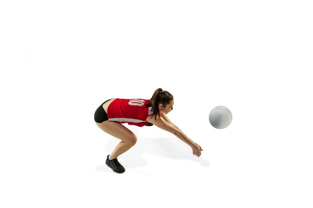 In jump and flight. Young female volleyball player isolated on white studio background. Woman in sportswear and sneakers training, playing. Concept of sport, healthy lifestyle, motion and movement.