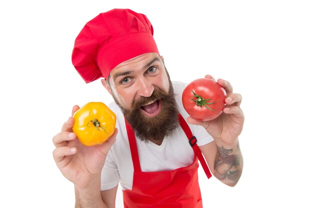 Перейти на диету. счастливый бородатый повар держит помидоры. профессиональный повар готовит вегетарианские блюда. готовим витаминные овощи. ежедневная диета. вегетарианская или веганская диета. диета и диета. здоровое питание.