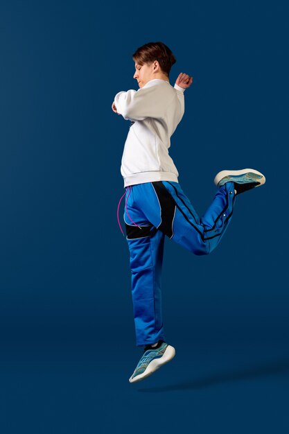 Jumping. Old-school fashioned young man dancing isolated on blue studio