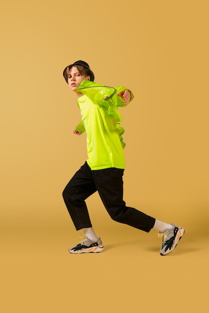 Прыжки. Олдскульный молодой человек танцует изолированно на желтой студии