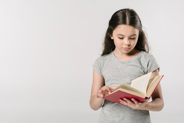 Junior girl reading book in studio