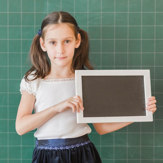 Free photo junior holding blackboard frame