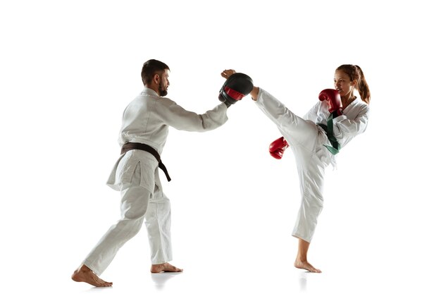 Junior in kimono practicing hand-to-hand combat with coach