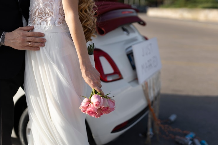 Free Photo just married couple next to little car
