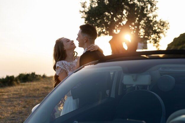 Just married couple next to little car