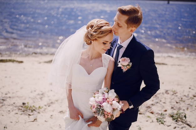 Just-married couple posing next to the seashore