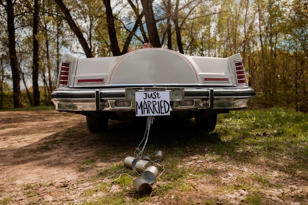 Free photo just married couple with their car