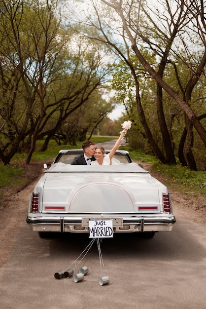 Foto gratuita coppia appena sposata con la propria auto