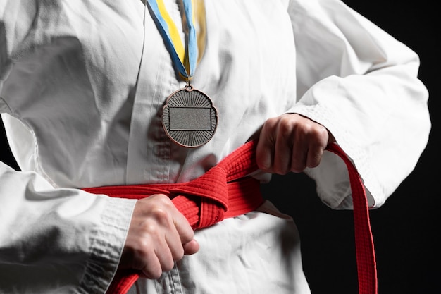 Karate athlete with red belt and medal