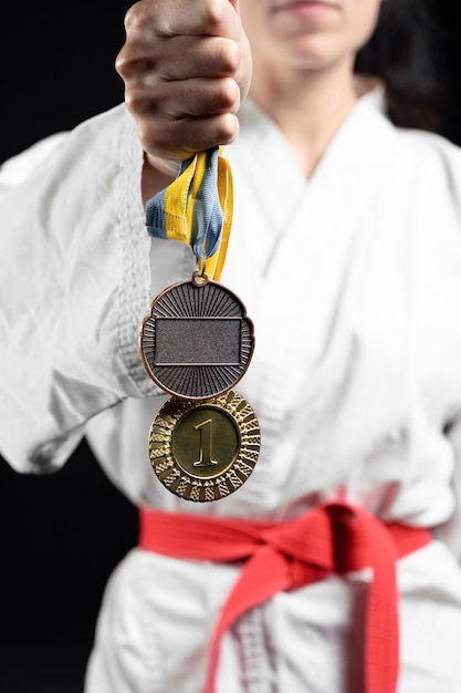 Foto gratuita atleta di karate con cintura rossa e medaglie