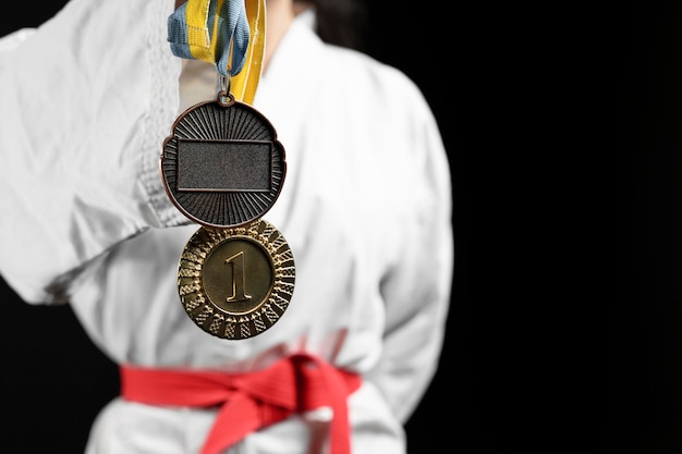 Спортсмен каратэ с красным поясом и медалями